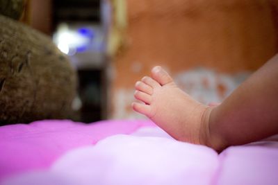 Low section of baby feet on bed