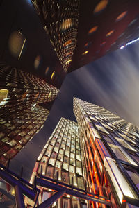 Directly below view of illuminated skyscrapers in city at night