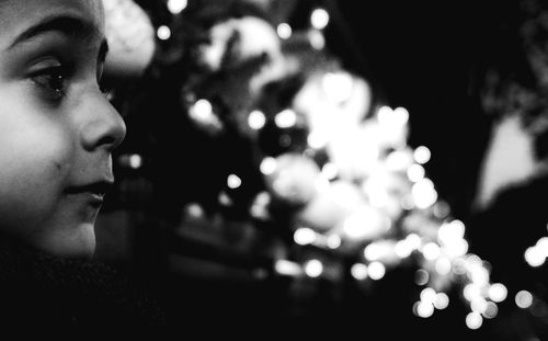 Close-up of boy against illuminated lights