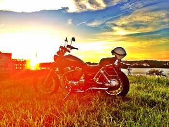 Scenic view of grassy field against sky at sunset