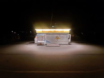 Illuminated electric lamp on street in city at night