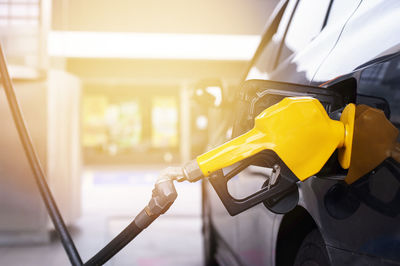 Refueling the car.close up shot of petrol nozzle while filling the car tank at the petrol station.