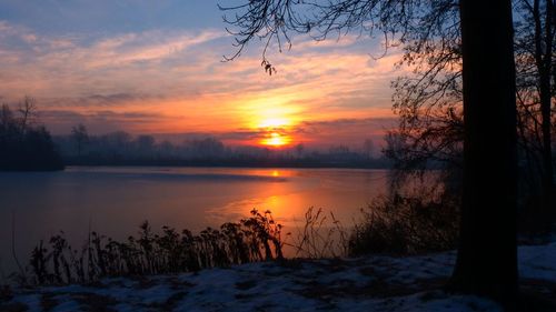 Scenic view of lake against orange sky during sunset