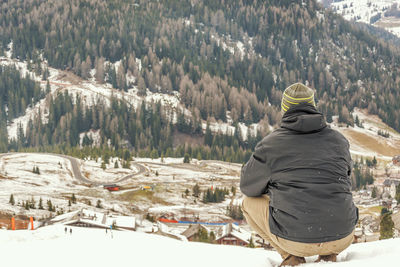 Rear view of man looking at mountain during winter