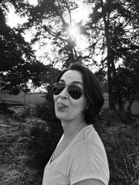 Portrait of young woman in sunglasses against sky