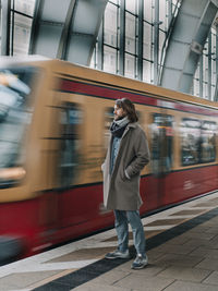 Rear view of man walking on railroad station