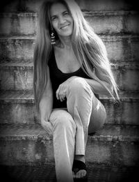 Portrait of smiling woman sitting on staircases