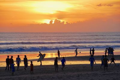 Silhouette people at beach during sunset