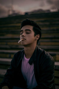 Young man smoking cigarette on steps