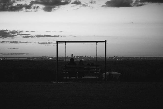 sky, men, silhouette, lifestyles, rear view, leisure activity, sitting, person, sea, cloud - sky, horizon over water, standing, full length, bench, nature, togetherness, relaxation