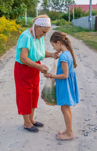 Side view of mother and daughter standing on beach