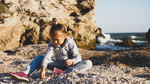 Girl sitting on rock at beach