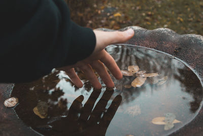 Close-up of hand touching water