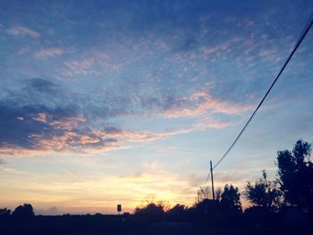 Low angle view of silhouette trees against sky