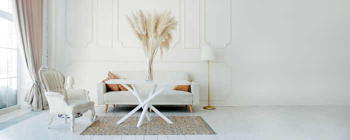 Empty chairs and table against wall at home