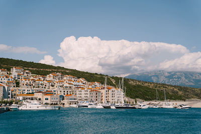 Scenic view of sea by buildings against sky