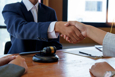 Midsection of lawyer shaking hands