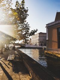 Buildings by river against clear sky