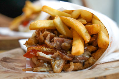 Close-up of burger with meat and fries in plate