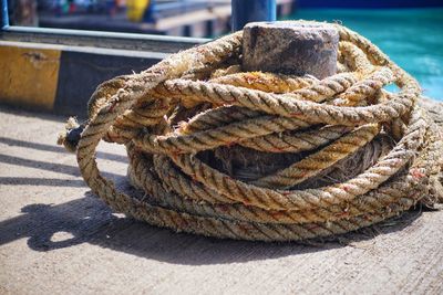 Close-up of rope tied to bollard on pier