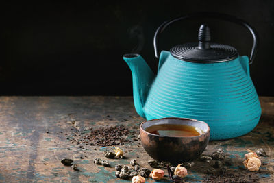 Close-up of tea cup on table against black background