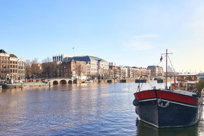 Boats in sea against clear sky