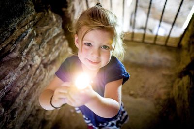 High angle view of girl holding flashlight