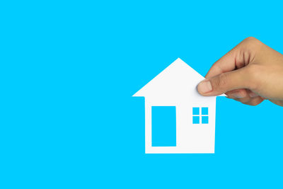 Close-up of person hand against blue background