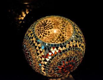 Close-up of illuminated lighting equipment against black background