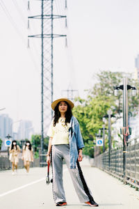 Portrait of young woman on road in city