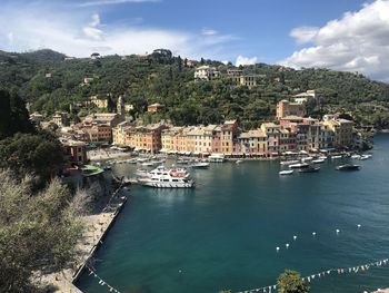 Scenic view of townscape by sea against sky