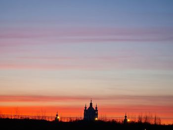Silhouette of building against cloudy sky during sunset