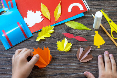 High angle view of hand holding paper on table