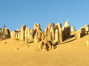 Panoramic view of desert against clear blue sky