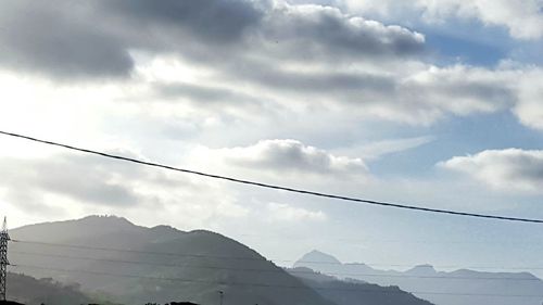 Low angle view of mountain against cloudy sky