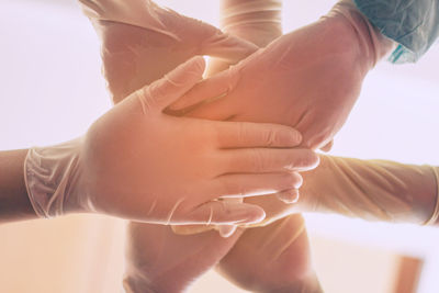 Close-up of couple holding hands over white background