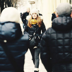 Rear view of people walking on street in winter