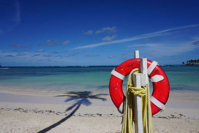 Lifeguard hut on beach against blue sky