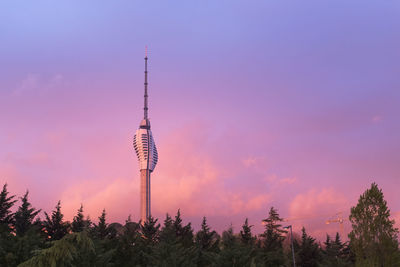 Low angle view of communications tower against sky during sunset