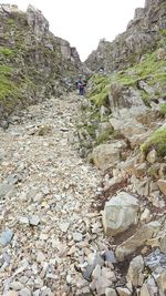 Low angle view of woman walking on cliff against sky