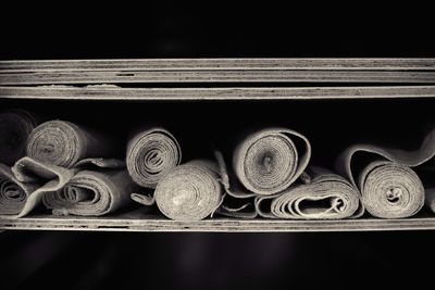 Close-up of rolled up fabrics in shelf at bakery