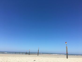 Scenic view of beach against clear blue sky