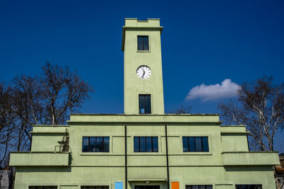 Low angle view of clock tower against blue sky