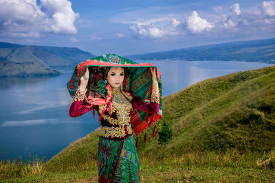 Portrait of woman standing on mountain against sky