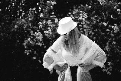 Woman with umbrella standing against plants