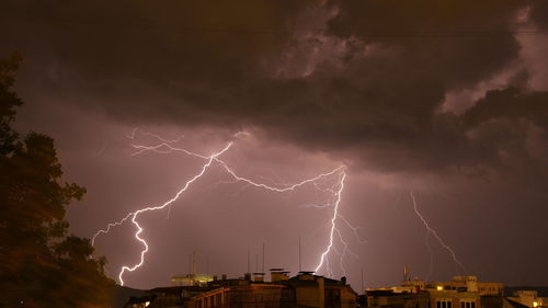 Low angle view of lightning against buildings at night