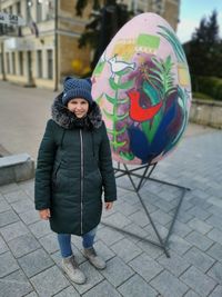 Portrait of smiling girl standing on footpath