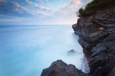 Rock formations in sea against sky