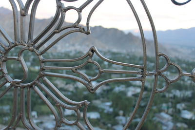 Close-up of metal fence against sky