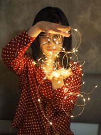Close-up of woman holding illuminated lights